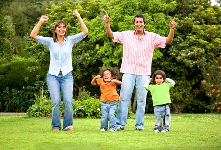 happy family portrait outdoors having fun jumping around