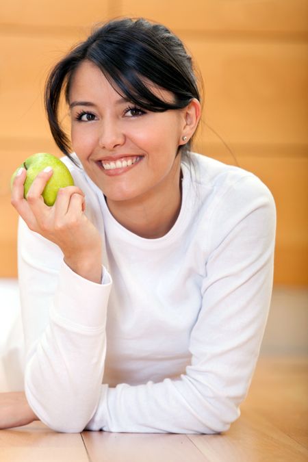 Beautiful woman holding an apple and smiling