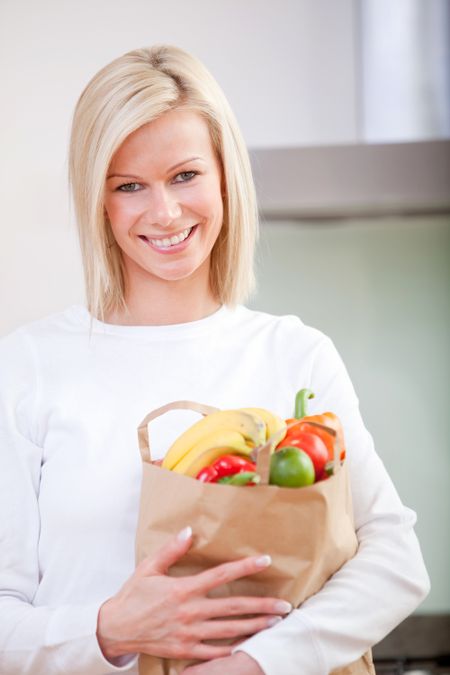 Shopping woman carrying groceries in a paper bag