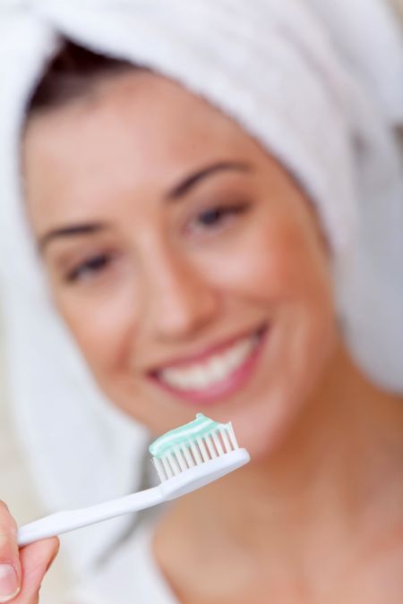 Woman holding a toothbrush in front of her face