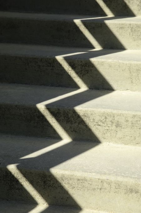 Zigzag shadow on sunlit concrete stairway