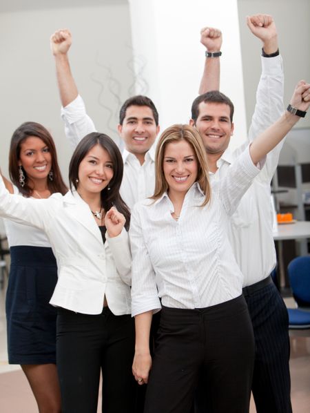 Group of business people with arms up at the office