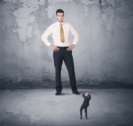 Big angry business bully looking at small coworker concept on background