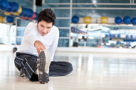 Man doing stretching exercises for his leg at the gym