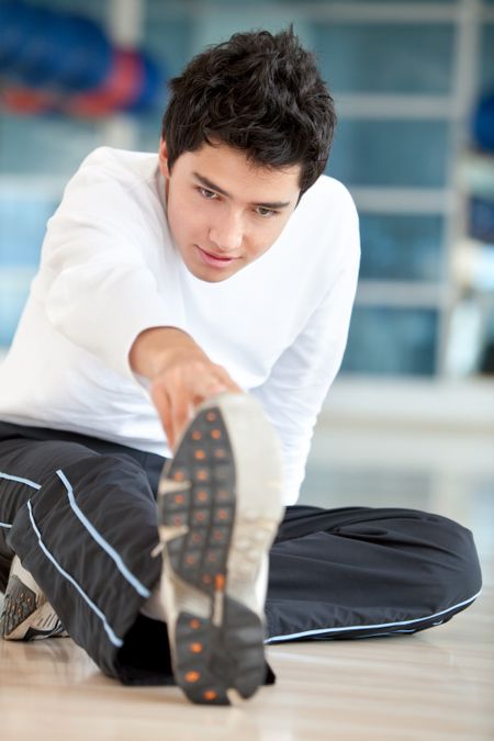 Man doing stretching exercises for his leg at the gym