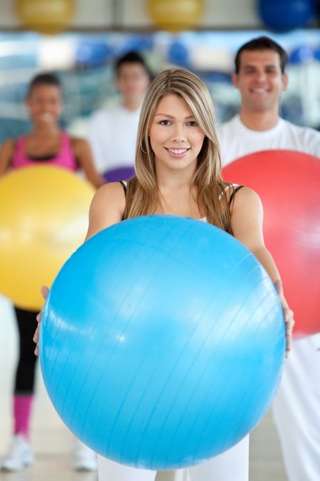 beautiful woman portrait at the gym smiling with a pilates ball