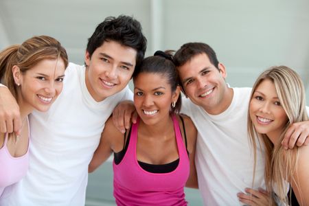 Group of athletic young people at the gym smiling