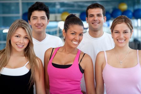 Group of athletic young people at the gym smiling