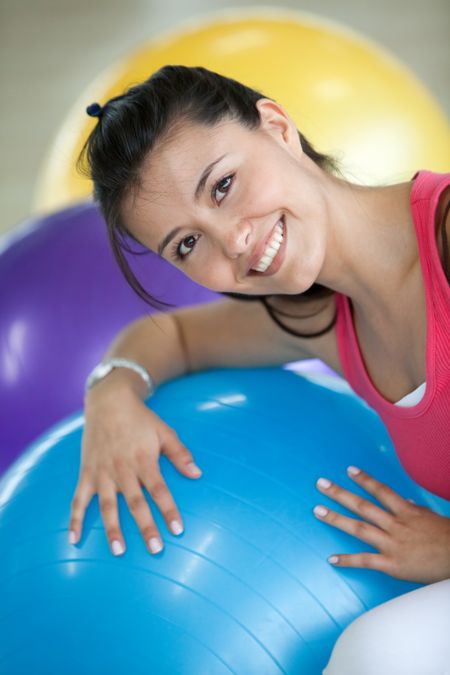 Beautiful woman portrait at the gym smiling with a pilates ball