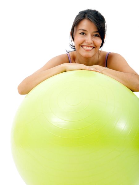 fitness woman leaning on a pilates ball isolated over a white background