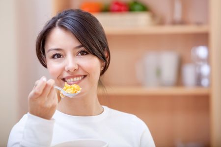 Woman at home eating cereals for breakfast