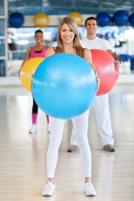group-people-gym-smiling-pilates-ball-57444919 Group of people at the gym smiling with a pilates ball