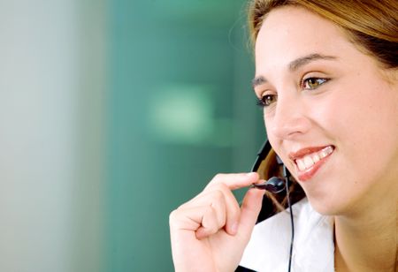 customer service girl smiling with hand on headset microphone in an office