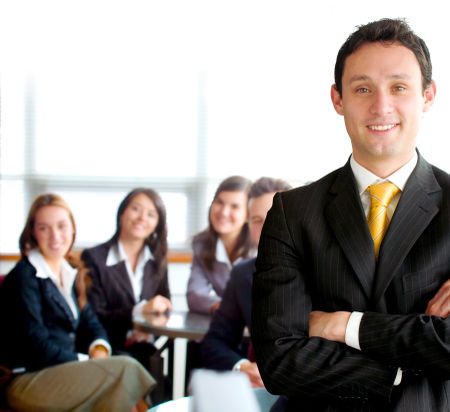 business man leading a team in an office environment smiling