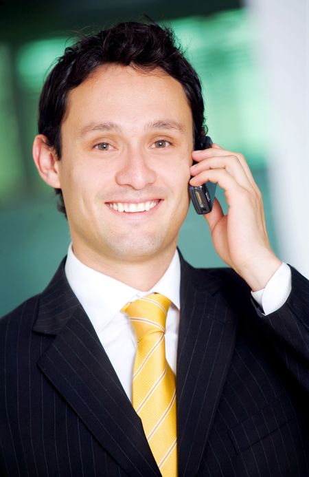 Business man on the phone in an office smiling