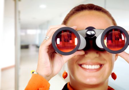 business woman searching for a job in an office - looking through binoculars