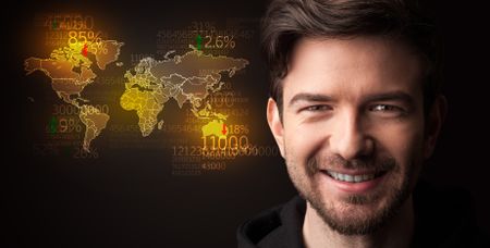 Portrait of a young businessman with a world map and numbers next to him on a dark background