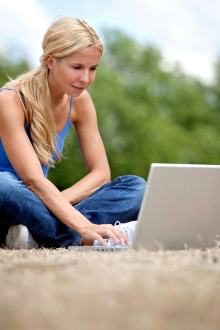 Woman working on a laptop computer outdoors