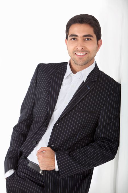 Confident business man leaning against a wall and smiling