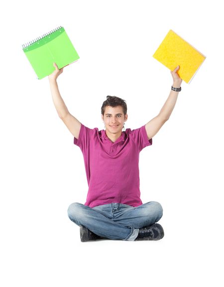 Happy male student sitting on the floor holding notebooks - isolated