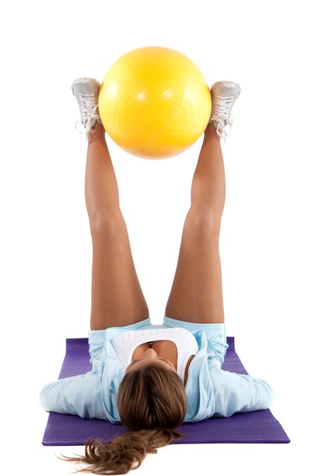 Woman exercising with a pilates ball - isolated over a white background