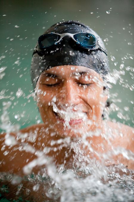 Portrait of a man swimming wearing a cap and goggles