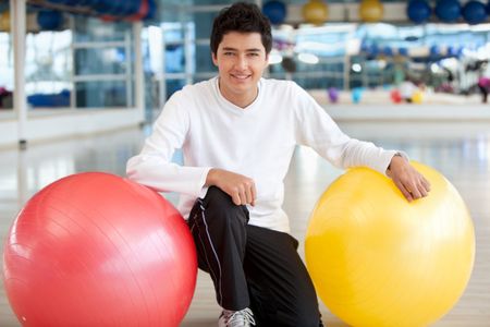 Man at the gym smiling with a pilates ball