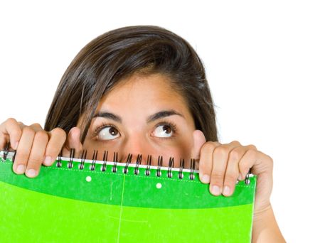 female student covering her face with a notebook isolated over white