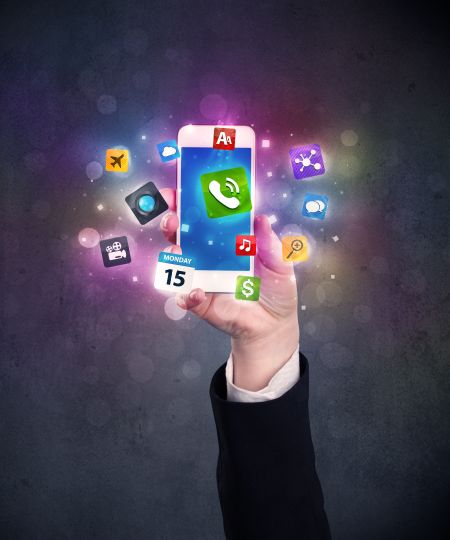 Caucasian hand in business suit holding a smartphone with colorful media icons