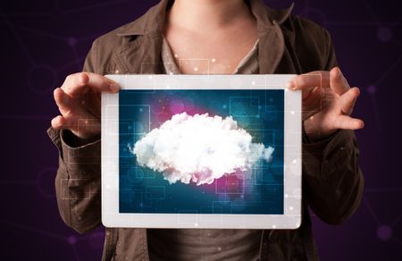 Casual young woman holding tablet with cloud concept and purple background 