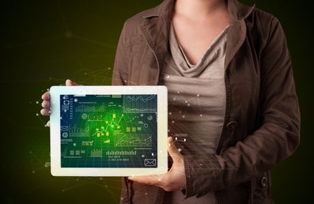 Casual young woman holding tablet with strategy and business related graphics