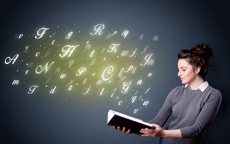 Casual young woman holding book with shiny letters flying out of it