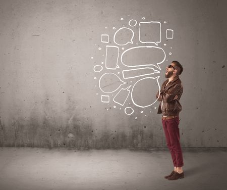 A comic hipster guy shouting in front of grey urban concrete wall with drawn empty text bubbles around his mouth concept