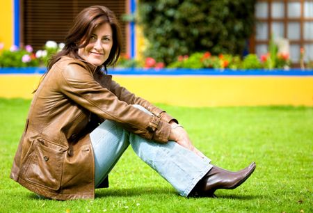 beautiful casual woman portrait at home outdoors sitting on the grass