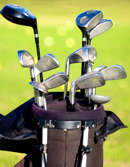 golf clubs in a bag with a course in the background