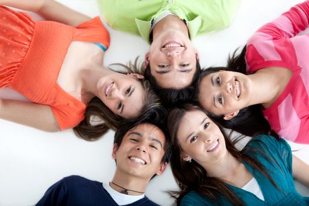 Circle of people lying on the floor and smiling - isolated over white background
