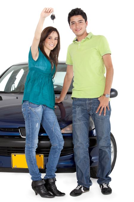 Young couple holding the keys of a car - isolated over a white background