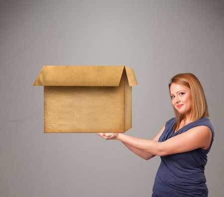 Beautiful young woman holding an empty cardboard box