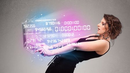 Attractive casual woman holding laptop with exploding data and numers