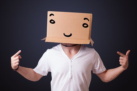 Young man standing and gesturing with a cardboard box on his head with smiley face