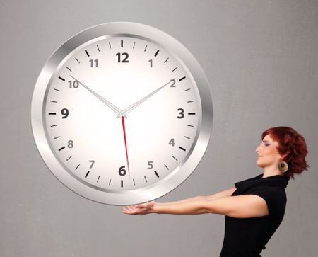 Attractive young lady holding a huge clock