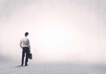 Serious business man standing on grey brick floor and thinging about decisions concept