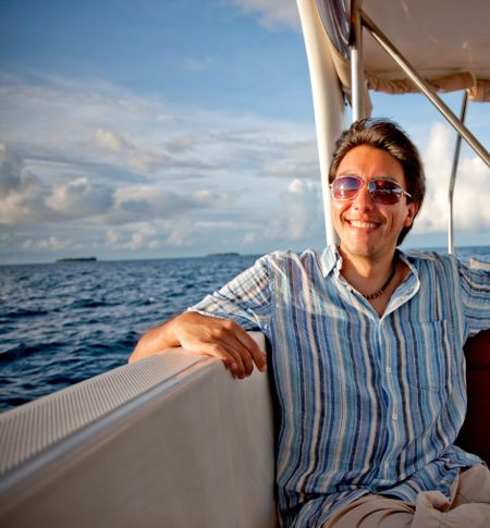 Happy man in a yacht or sailing boat enjoying life