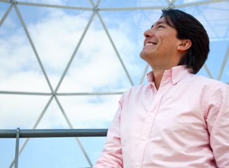 Thoughtful man looking at the sky and smiling in a dome