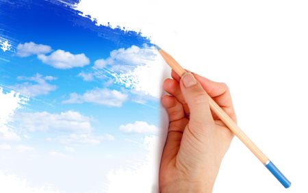 Hand holding a color pencil and drawing a blue sky
