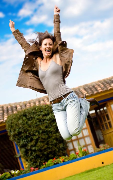 happy girl jumping and smiling portrait outside her home