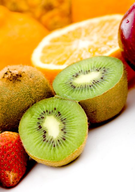 delicious fruit of all kinds isolated over a white background - focus is on kiwi
