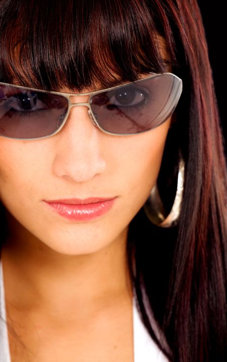 fashion girl portrait wearing sunglasses over a dark background