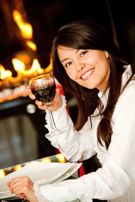 Beautiful woman at a restaurant holding a glass of wine and smiling