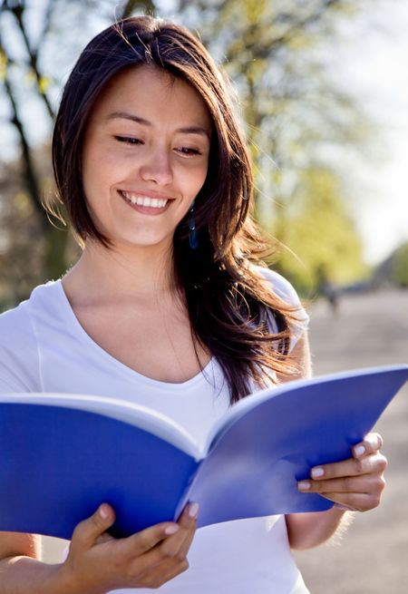 Beautiful female student outdoors with a notebook